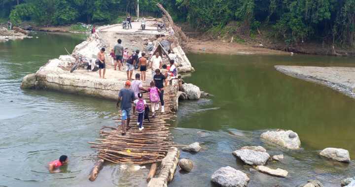 Cruzan río Camú usando un puente de tablitas